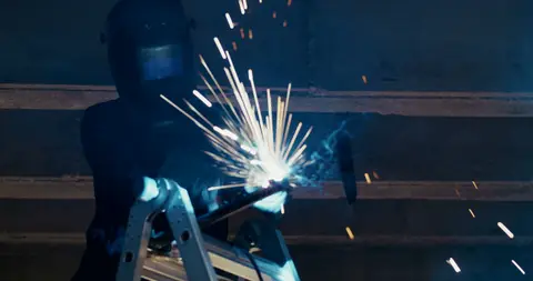 Strong welding action frame with sparks and clear construction activity.