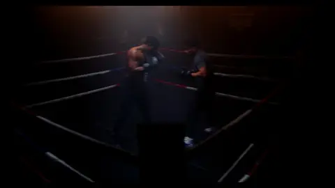 Third-pass frame candidate. Source-level review: Dramatic boxing silhouettes and ring atmosphere, but many frames are very dark, motion-heavy, or face/athlete dependent. Individual frame still requires close visual review unless source-level decision is reject.