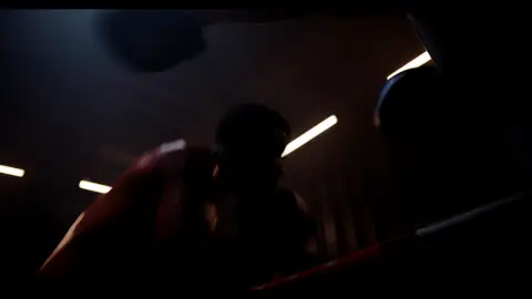 Third-pass frame candidate. Source-level review: Dramatic boxing silhouettes and ring atmosphere, but many frames are very dark, motion-heavy, or face/athlete dependent. Individual frame still requires close visual review unless source-level decision is reject.