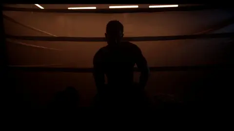 Third-pass frame candidate. Source-level review: Dramatic boxing silhouettes and ring atmosphere, but many frames are very dark, motion-heavy, or face/athlete dependent. Individual frame still requires close visual review unless source-level decision is reject.