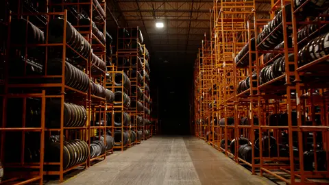 Third-pass frame candidate. Source-level review: Strong warehouse/tire/forklift material with better subject clarity than earlier passes. The orange fast-pan smear and obstructed worker frames are explicitly excluded. Individual frame still requires close visual review unless source-level decision is reject.