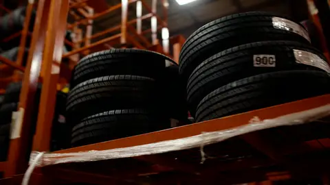 Third-pass frame candidate. Source-level review: Strong warehouse/tire/forklift material with better subject clarity than earlier passes. The orange fast-pan smear and obstructed worker frames are explicitly excluded. Individual frame still requires close visual review unless source-level decision is reject.