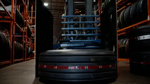 Third-pass frame candidate. Source-level review: Strong warehouse/tire/forklift material with better subject clarity than earlier passes. The orange fast-pan smear and obstructed worker frames are explicitly excluded. Individual frame still requires close visual review unless source-level decision is reject.