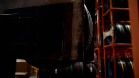Third-pass frame candidate. Source-level review: Strong warehouse/tire/forklift material with better subject clarity than earlier passes. The orange fast-pan smear and obstructed worker frames are explicitly excluded. Individual frame still requires close visual review unless source-level decision is reject.