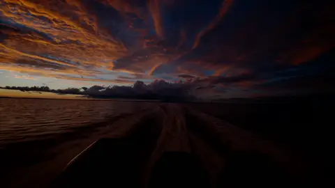 Strong dramatic sunset/coastal frame with clear sky texture and movement path.