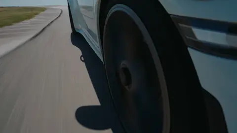 Strong wheel-rig track detail with speed, curb texture, and a clear automotive subject.