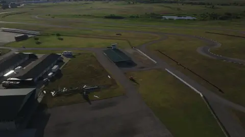 Strong aerial overview showing the racetrack layout, buildings, and surrounding landscape.