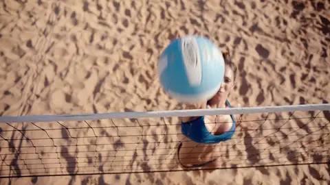 Strong overhead/net volleyball action with ball and athlete aligned to the court.