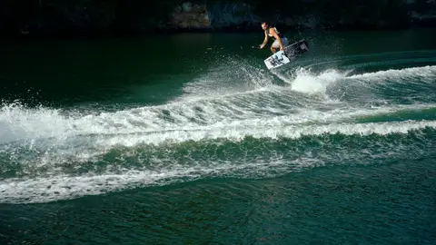 Strong wake action frame with rider, spray, and clear boat/water sport energy.