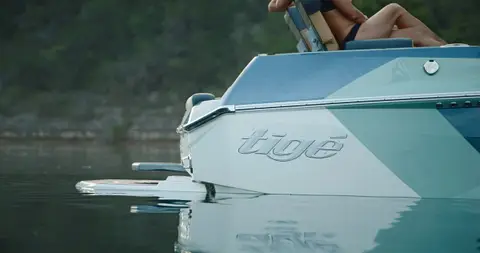 Useful Tige logo/detail crop with water texture, but tight crop and visible body crop need review.